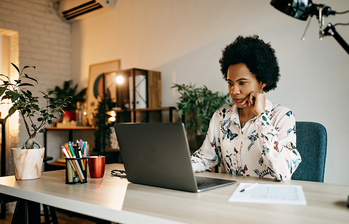 woman sitting at a desk behind a laptop